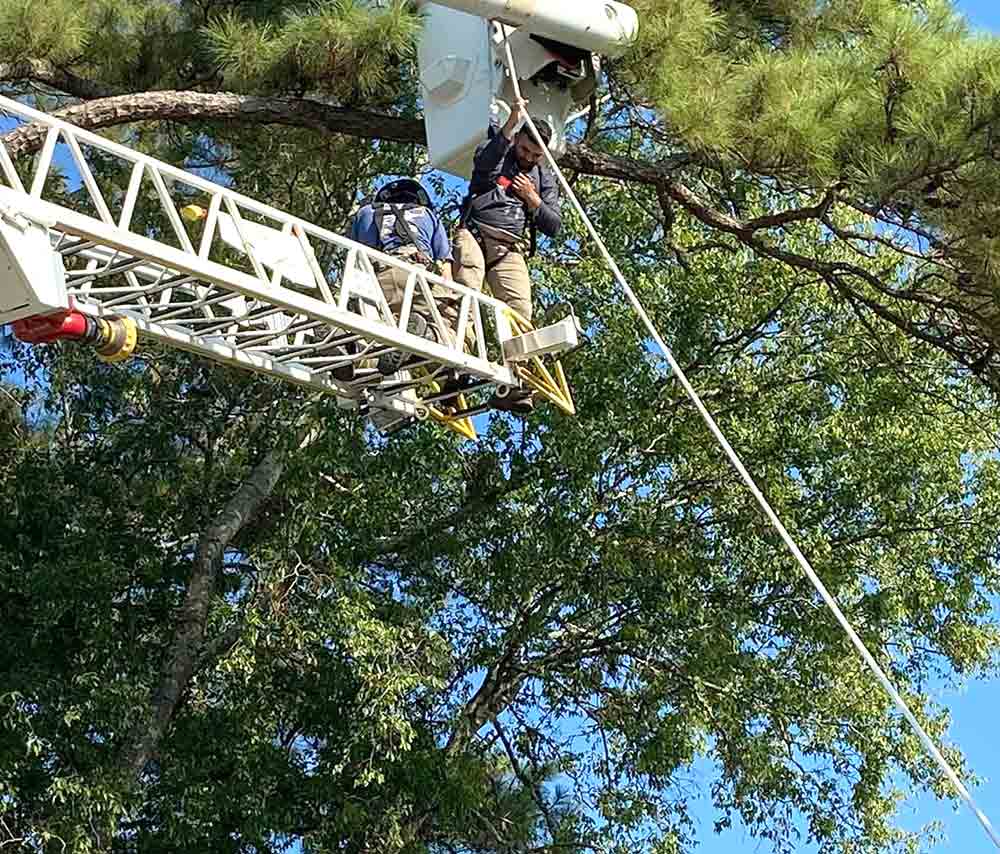 Apple Springs VFD firefighters assist a worker who was hanging from a bucket truck. Courtesy photo