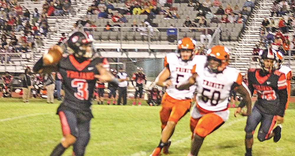 Coldspring-Oakhurst quarterback Duke Lawniczak (3) rolls out as he looks for an open wide receiver during the Trojans’ 48-8 rout of Trinity last Friday. (Photo by Scott Womack)